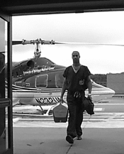 Organ preservationist arriving at transplant hospital via helicopter, carrying cooler with a kidney for transplant inside.